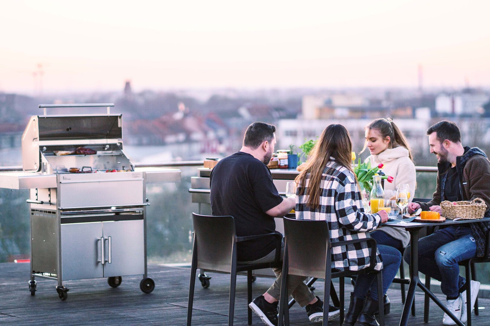 Grillen und Genießen über den Dächern der Stadt: Mit stabilen Beistelltischen aus Edelstahl hat man hier ganz andere Möglichkeiten | © djd/Schickling Grill