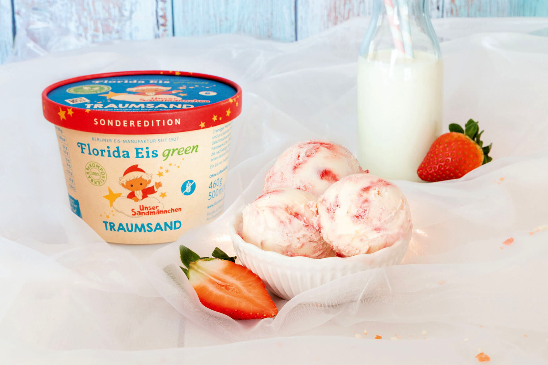 Prickelnde Knisterstückchen sorgen im Milcheis mit Erdbeersauce für den "Traumsand"-Effekt.