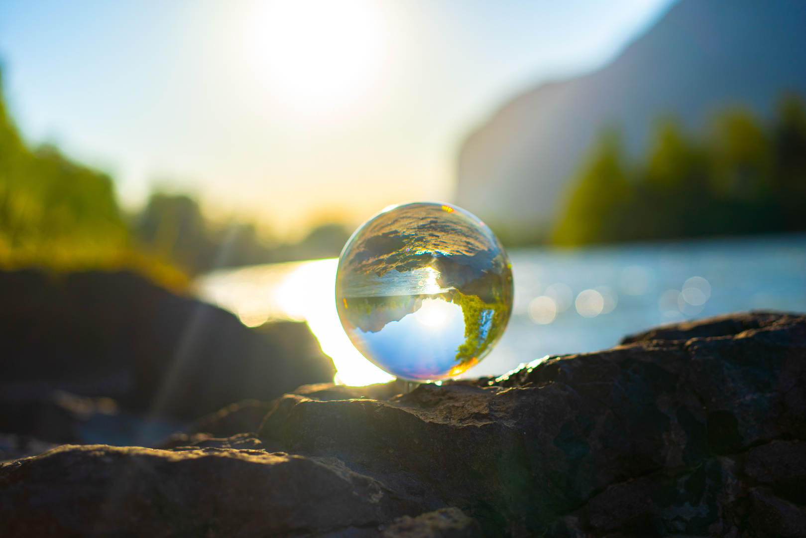 A Glass ball surrounded by nature. In the back you can see the river called Inn. | © Unsplash / Alin Andersen